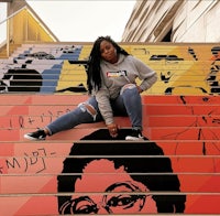 a woman sitting on a set of colorful stairs
