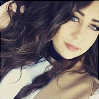 a woman with long brown hair is posing for a photo